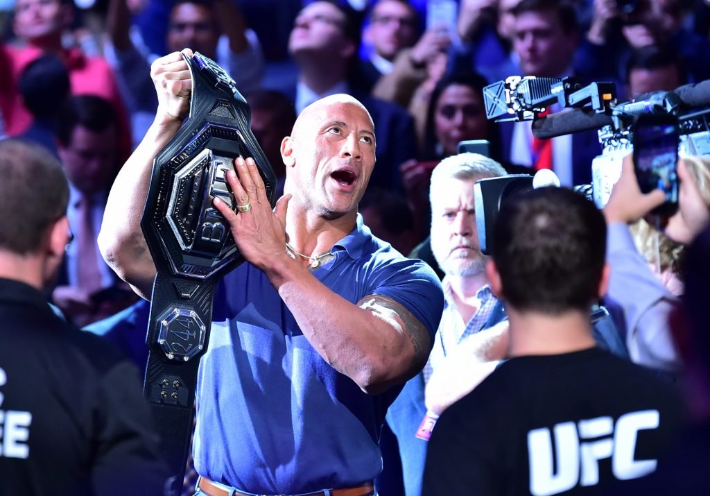 Dwayne Johnson, AKA The Rock, raises the BMF belt during a UFC event.